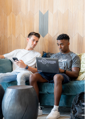 Two men sitting and using a laptop